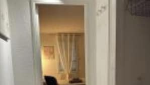 A narrow hallway leading to a room with a bed, a chair, and a table. - Studio in the heart of Dijon (Dijon)