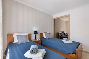 A hotel room with two beds, wooden headboards, and a large mirror.