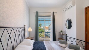 Une chambre d’hôtel avec un lit, une table de chevet, une lampe, un miroir et une vue sur l’extérieur.