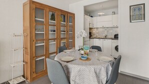 A dining area with a wooden cabinet, a metal rack, and a table set for four.