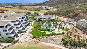 Een resort met moderne gebouwen, een zwembad en aangelegde tuinen.