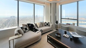 A modern living room with a sofa, coffee table, and large windows offering a city view.