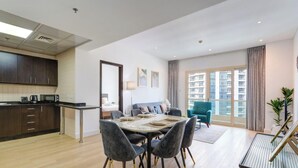 Un apartamento moderno con comedor, cocina y un amplio ventanal con vistas a la ciudad.