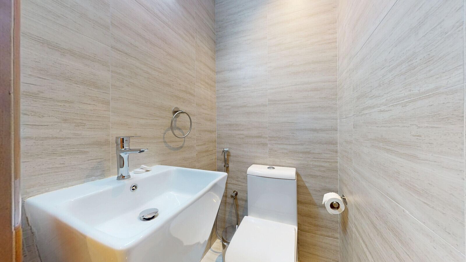 Une salle de bain avec un lavabo, des toilettes et une douche, le tout de couleur blanche.
