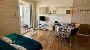Una habitación acogedora con una cama, un escritorio con una computadora, una silla y una mesa con mantel decorado.
