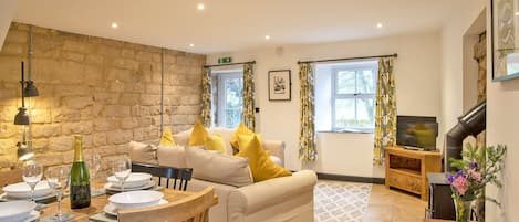 Relax in this inviting living area with a sofa, dining table, and television.