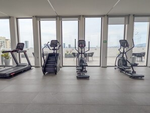 A gym with treadmills, an elliptical, and a stair climber. - Beautiful Luxury Apartment Near Andares! (Zapopan)