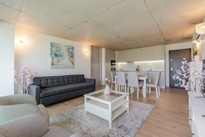 Una sala moderna con sofá, mesa de centro y comedor.