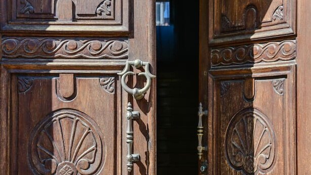 Una puerta de madera con tallas intrincadas y una cerradura.