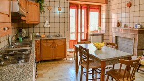 Una cocina con armarios de madera, encimera de granito, cocina a gas y una mesa de comedor con sillas.
