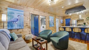 Un acogedor interior de cabaña con sala de estar, comedor y kitchenette.