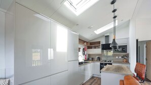 A modern kitchen with white cabinetry, a wooden countertop, and a built-in oven. - 2 bedroom accommodation in Old Langho, Ribble Valley (Old Langho, Ribble Valley)