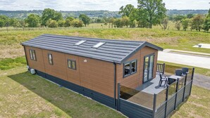 A single-story, brick building with a flat roof, a deck with seating, and a fenced outdoor area. - 2 bedroom accommodation in Old Langho, Ribble Valley (Old Langho, Ribble Valley)