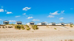 Eine Reihe von Strandhütten unter blauem Himmel.