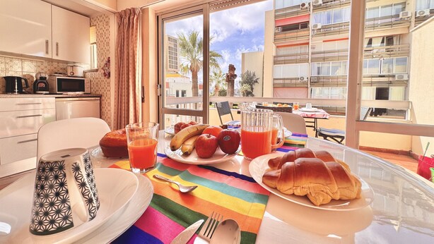 A breakfast table with plates, cutlery, and a colorful tablecloth. - VILAMOURA CENTRAL 10 by HOMING (Vilamoura)