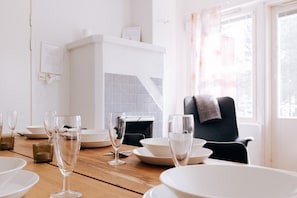 A dining area with a table set for a meal, featuring a chair and a window with a view.