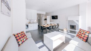 Una sala de estar moderna con un sofá, una mesa de centro y un comedor con sillas y una mesa.