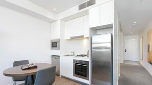 Una cocina moderna con microondas integrado, horno y refrigerador de acero inoxidable.