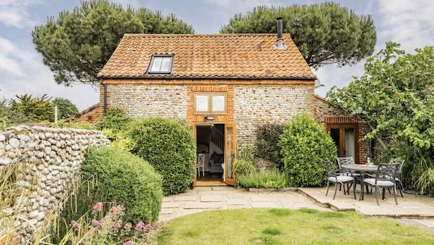 A stone house with a tiled roof, a wooden door, and a small window. - A beautiful barn conversion in the charming village of Langham (Langham)