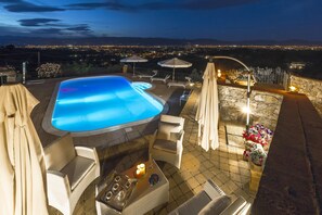 A rooftop pool area with lounge chairs, a hot tub, and a stone wall. - My Rental Homes - Villa delle Rose with private pool, barbeque and air conditioning (Serravalle Pistoiese)
