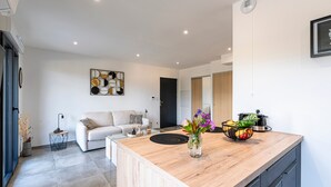 A modern kitchen with a wooden countertop, a vase with flowers, and a fruit bowl. - Les Vagues d'Agosta - Studio Apartment, Sleeps 2 (Albitreccia)