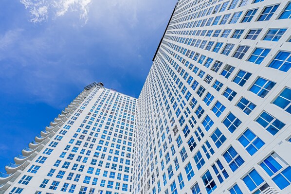 A tall, modern building with a grid of windows and a clear blue sky in the background. - w* | Sunlit 1BR on Avenida Balboa w/ Pool (Panamá)