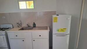 A compact kitchen with a gas stove, sink, and a white refrigerator. - Fair View Garden #2 (By-BLR) (Fair View)