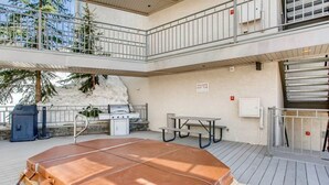 A rooftop deck with a hot tub, barbecue grill, and picnic table. - Crested Butte Mountain Resort Properties by Vail (Crested Butte)