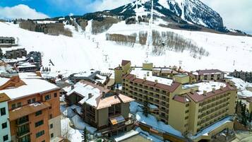 A hotel complex with multiple buildings, a ski slope in the background, and a mountain.