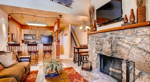 Relax in this stylish living room with a fireplace, sofa, and flat-screen TV.