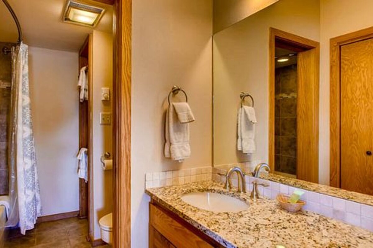 Une salle de bain avec une douche, deux lavabos et un grand miroir.