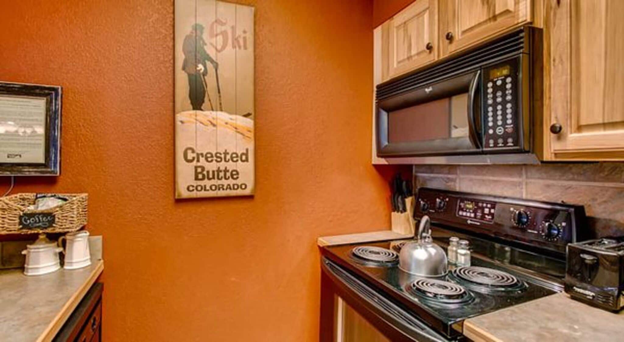 A kitchen with wooden cabinets, a stove, and a microwave.