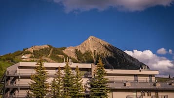 A hotel with a mountain view, multiple floors, and balconies.
