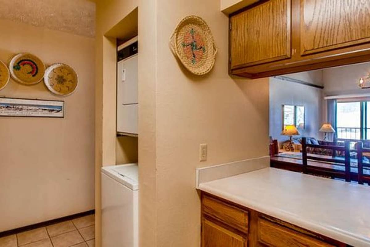 A kitchen with wooden cabinets, a white refrigerator, and a wall-mounted dish rack.