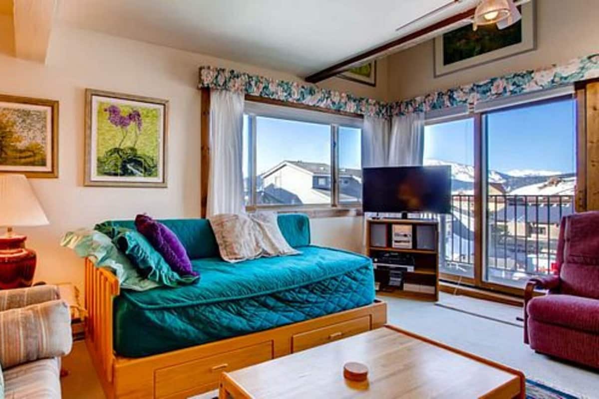 Ein gemütliches Zimmer mit einem Bett, einer Couch, einem Fernseher und einem Fenster mit Blick.