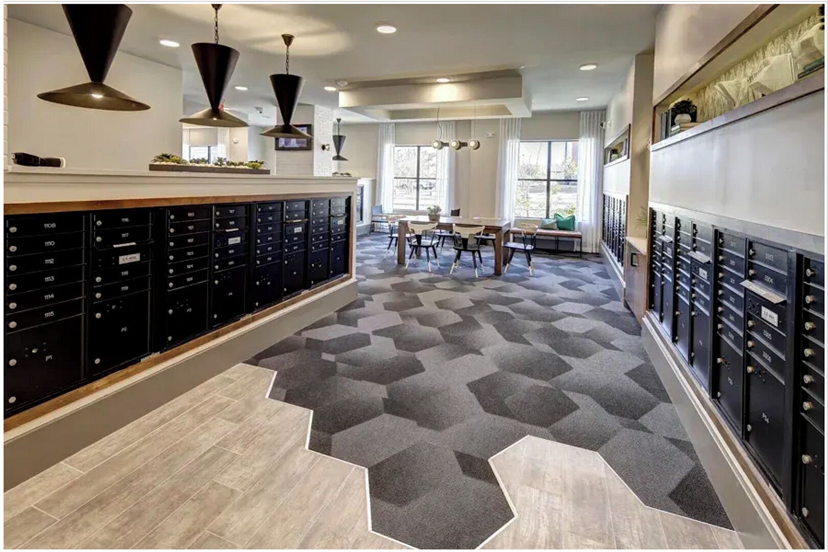 A modern interior with a geometric patterned carpet, black filing cabinets, and pendant lighting.