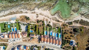 Une vue aérienne d’un quartier résidentiel avec plusieurs maisons, une piscine et une route.