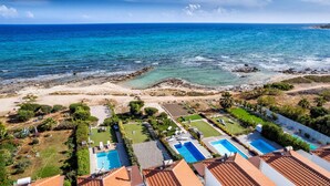 Une propriété située sur la côte, dotée d’une piscine, d’un patio et offrant une vue sur l’océan.