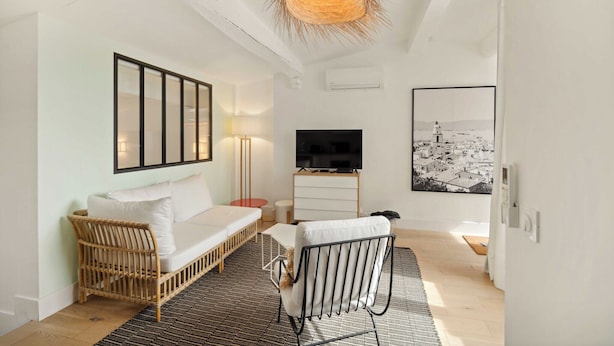 A modern, well-lit room with a sofa, a TV, and a large framed picture on the wall. - Magnificent apartment - AC- 2BR- Saint-Tropez (Saint-Tropez)