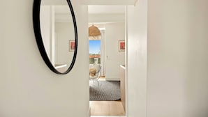 A hallway with a black-framed mirror, a patterned rug, and a chair with a cushion. - Magnificent apartment - AC- 2BR- Saint-Tropez (Saint-Tropez)