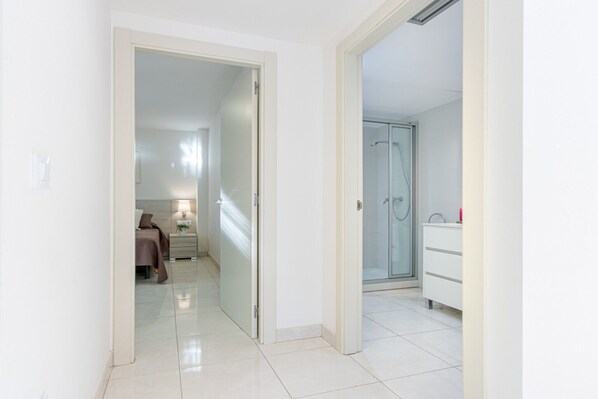 Une chambre d’hôtel comprenant un lit, une table de chevet, une lampe et une salle de bain avec douche et lavabo.