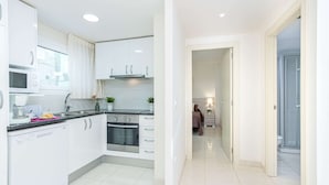 A modern kitchen with white cabinetry, a microwave, and a dishwasher.