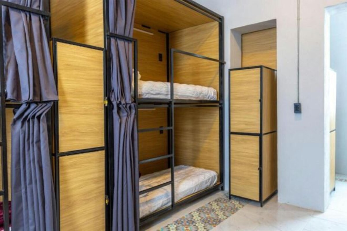 Een kamer met een stapelbed, een kledingkast en een kamerkleed met een patroon.