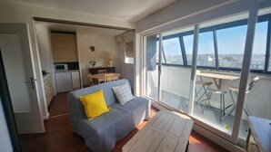 Eine moderne Wohnung mit Balkon, Essbereich und einer Küchenzeile.