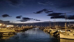 Una marina al crepuscolo, con barche ormeggiate lungo il canale.