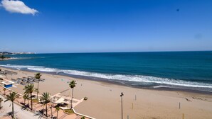 A beach with clear skies, a sandy shore, and a few palm trees. - Ref: 268 Stunning apartment on the beach front in Fuengirola with pool and parking (Fuengirola)