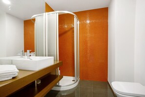 A modern bathroom with a white sink, mirror, and toilet, and a shower enclosure. - Apartment 'Macedo' with Sea View, Balcony and Wi-Fi (funchal)
