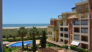 A hotel with a pool, a beach view, and a courtyard with palm trees. - Playa Grande 197 - Two Bedroom Apartment, Sleeps 5 (Punta del moral)