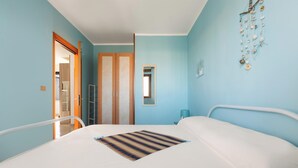 A bedroom with a large bed, a wooden wardrobe, and a small window. - Amor di Salento by BarbarHouse (San Foca)
