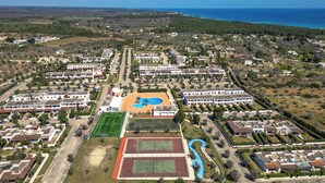 An aerial view of a residential area with multiple buildings, a swimming pool, and sports facilities. - Amor di Salento by BarbarHouse (San Foca)